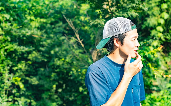 緑豊かな自然の中でキャップをかぶった若い男性の横顔